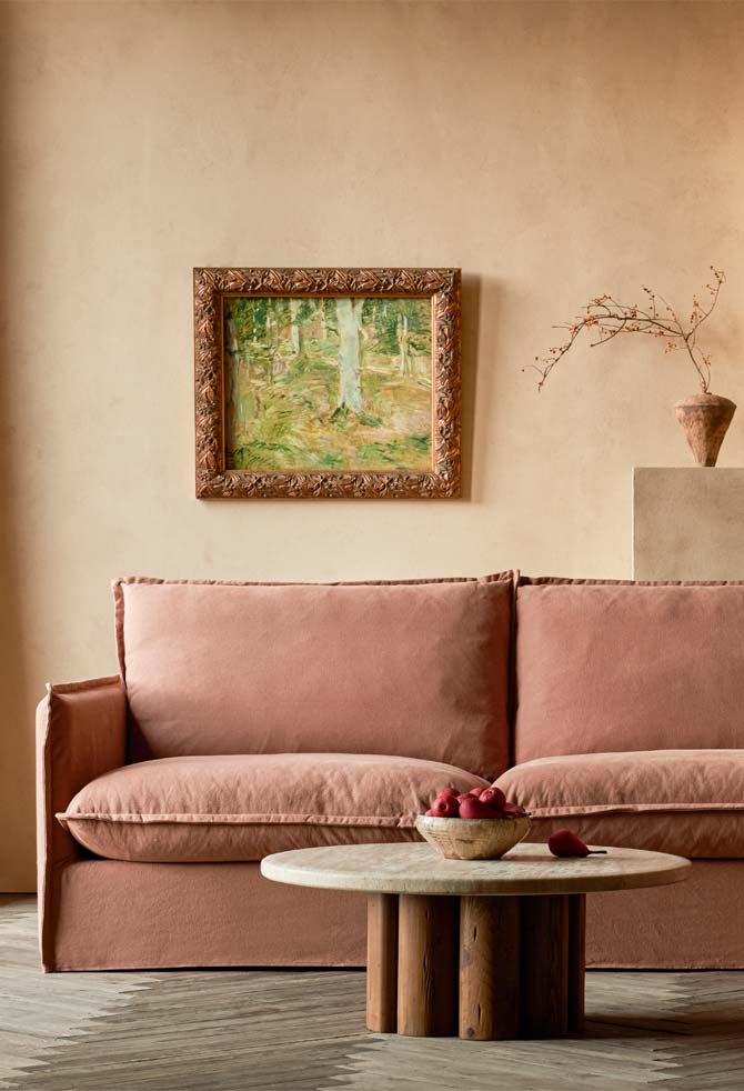 Neva L Shape Sectional in Thread-Dyed Cotton Linen Nectarine Dream placed in a living room beside the Enzo Coffee Table