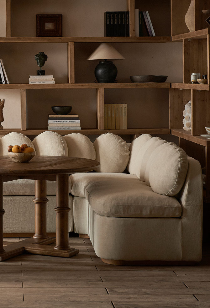 An Olea Banquette in Warm Oatmeal and Gio Chair in Heritage Ash surround a Pia Dining Table in Heritage Pine