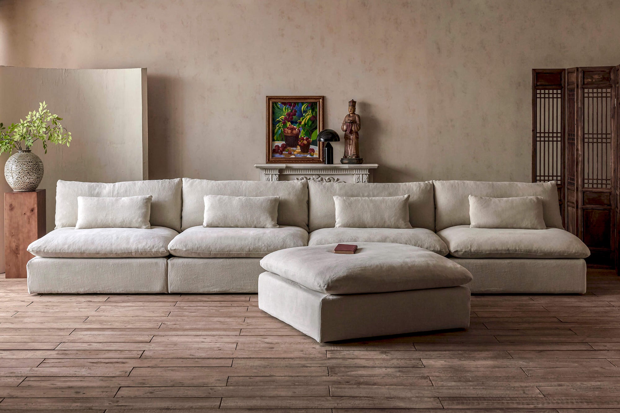 Aria Grande 5-piece Chaise Sectional Sofa in Warm Oatmeal, a light warm beige Medium Weight Linen, placed in a decorated room with a vase on a side table, a painting, and a table lamp set on a mantle behind it