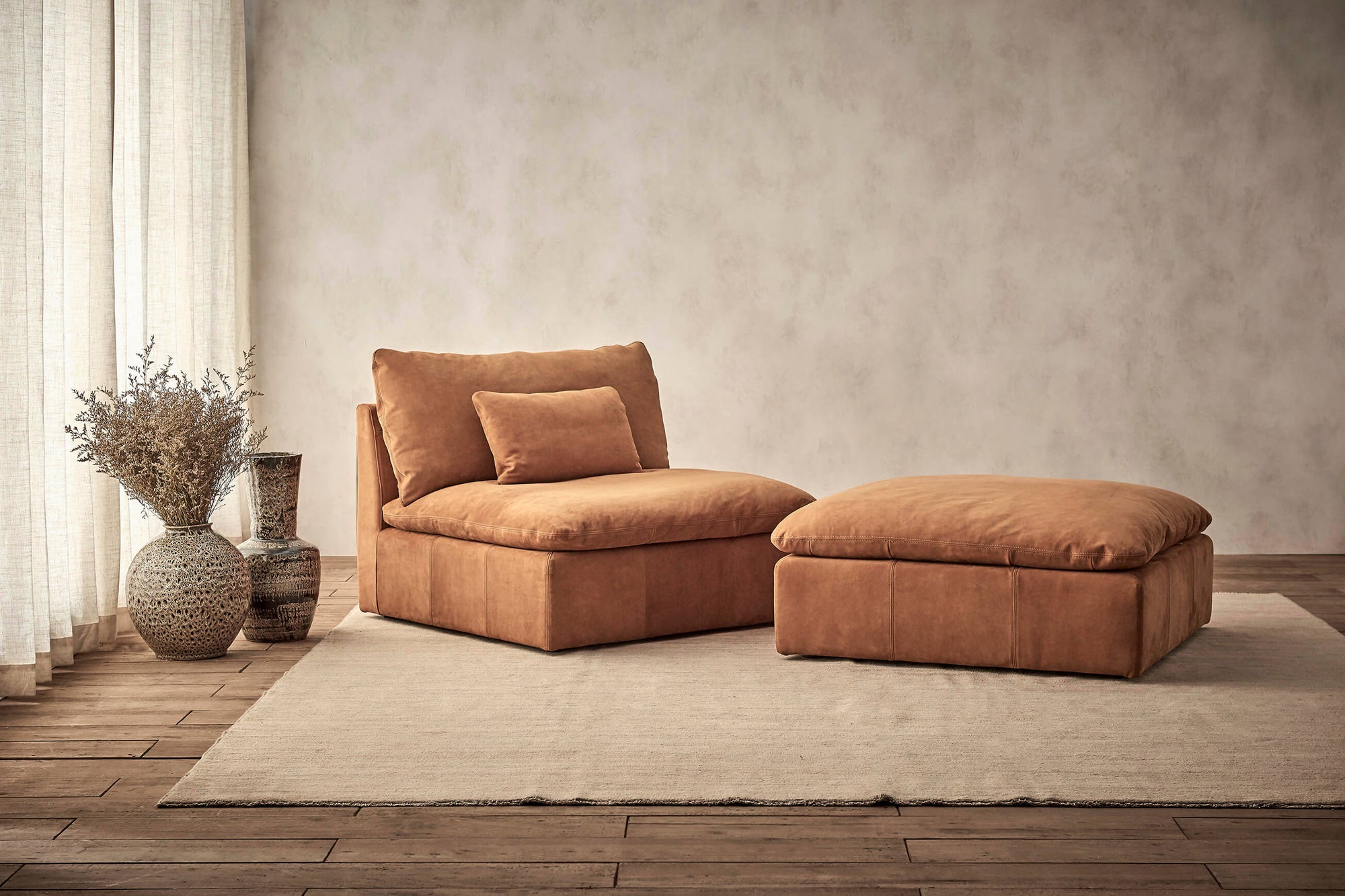 Aria Leather Chair in Sunset Canyon, a cognac brown Meridian Leather placed alongside the Aria Leather Ottoman