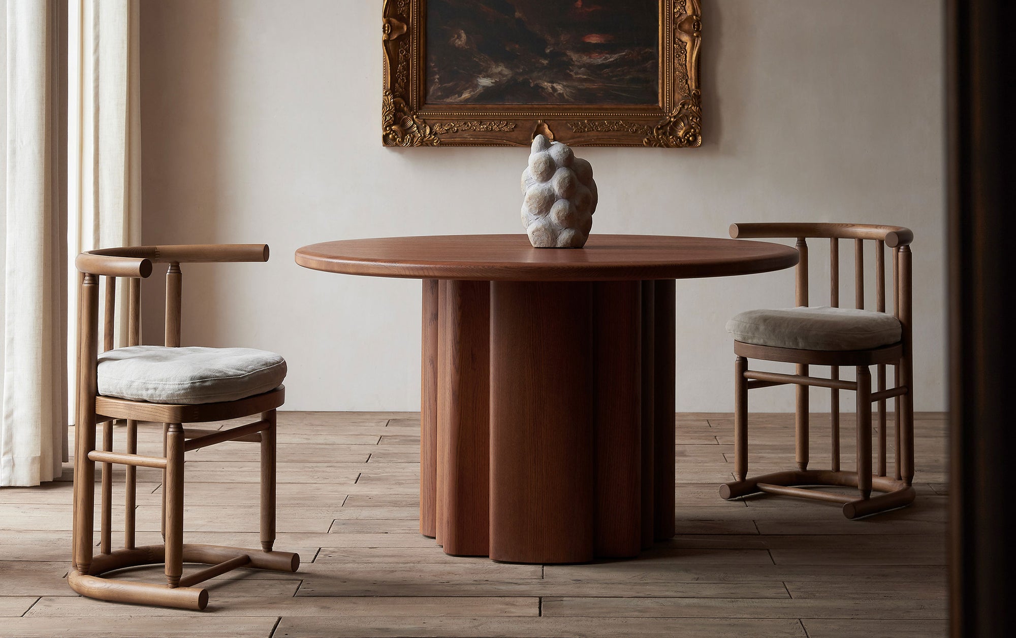 Two Bene Dining Chair in Heritage Ash wood and cushions in Warm Oatmeal, a light warm beige Medium Weight Linen, sitting at an Enzo Dining Table
