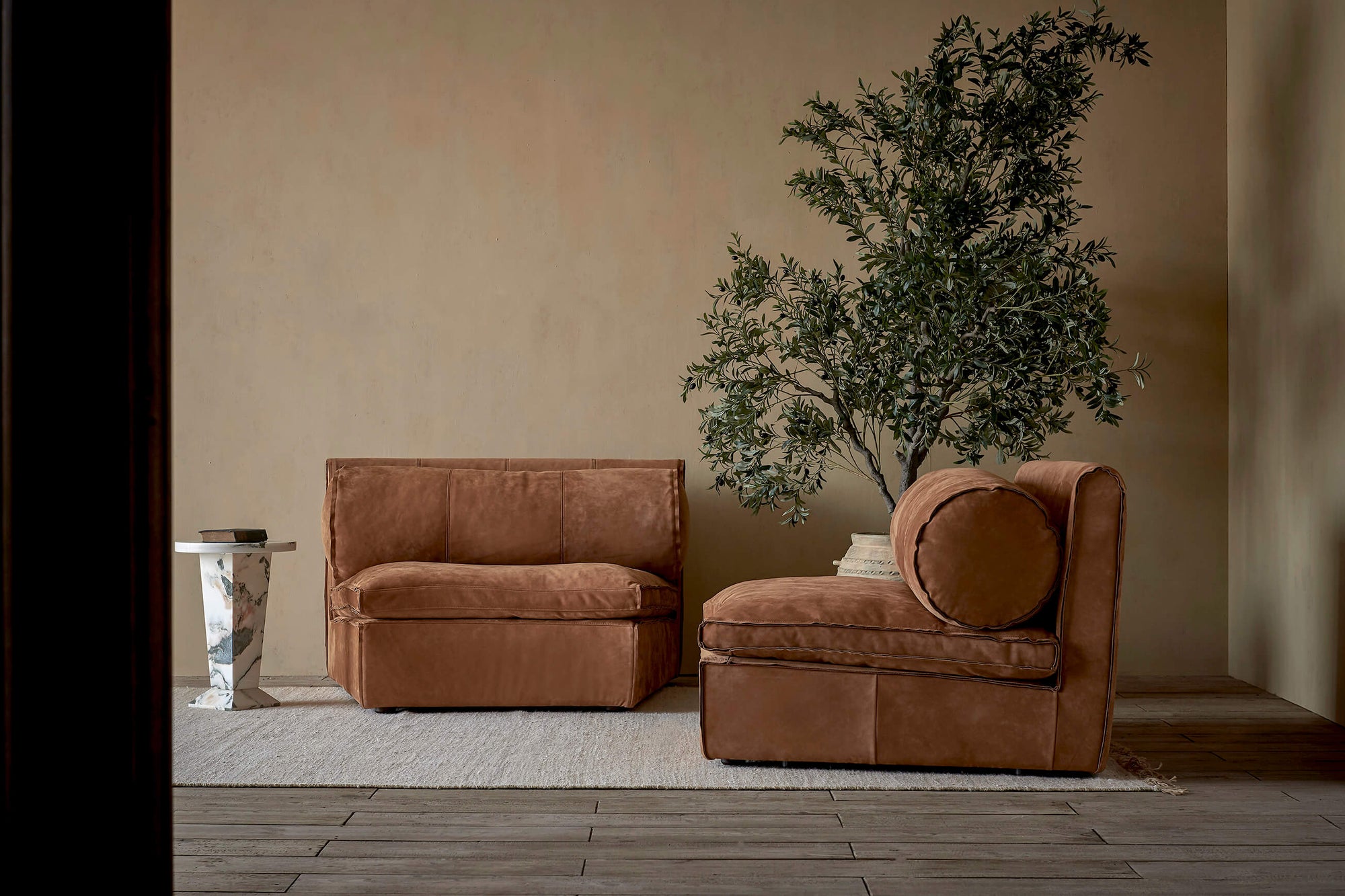 Two Camino Leather Chairs in Sunset Canyon, a cognac brown Meridian Leather placed on top of a rug in a room