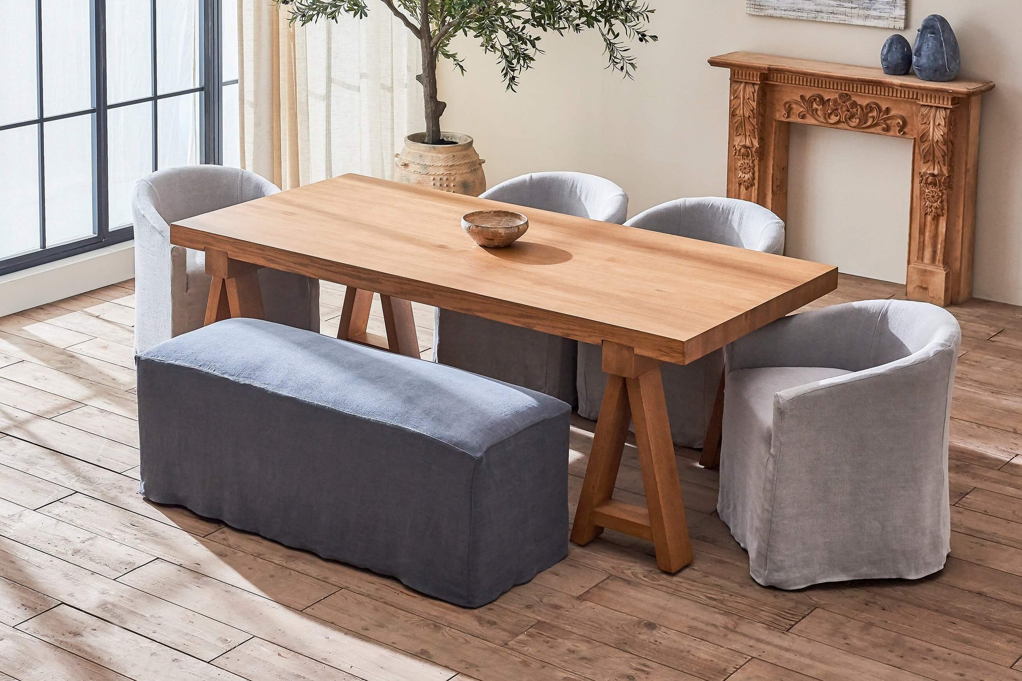Devyn Dining Bench in Black Pepper, a cool charcoal grey Light Weight Linen, placed in a room with Ziki Dining Chairs around a Rylance Dining Table.