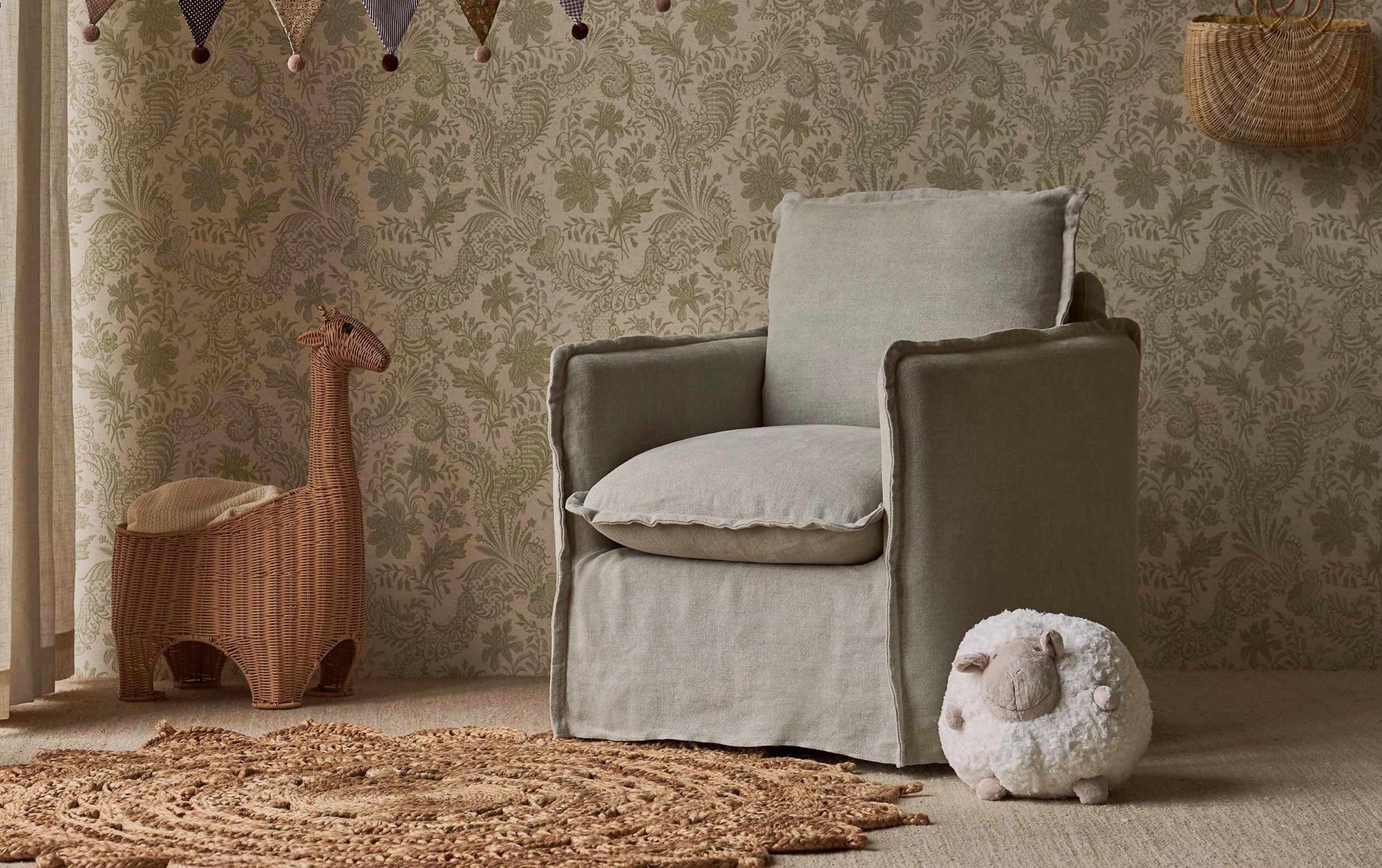 Neva Swivel Glider Chair in Jasmine Rice, a light warm greige Medium Weight Linen placed in a nursery decorated room