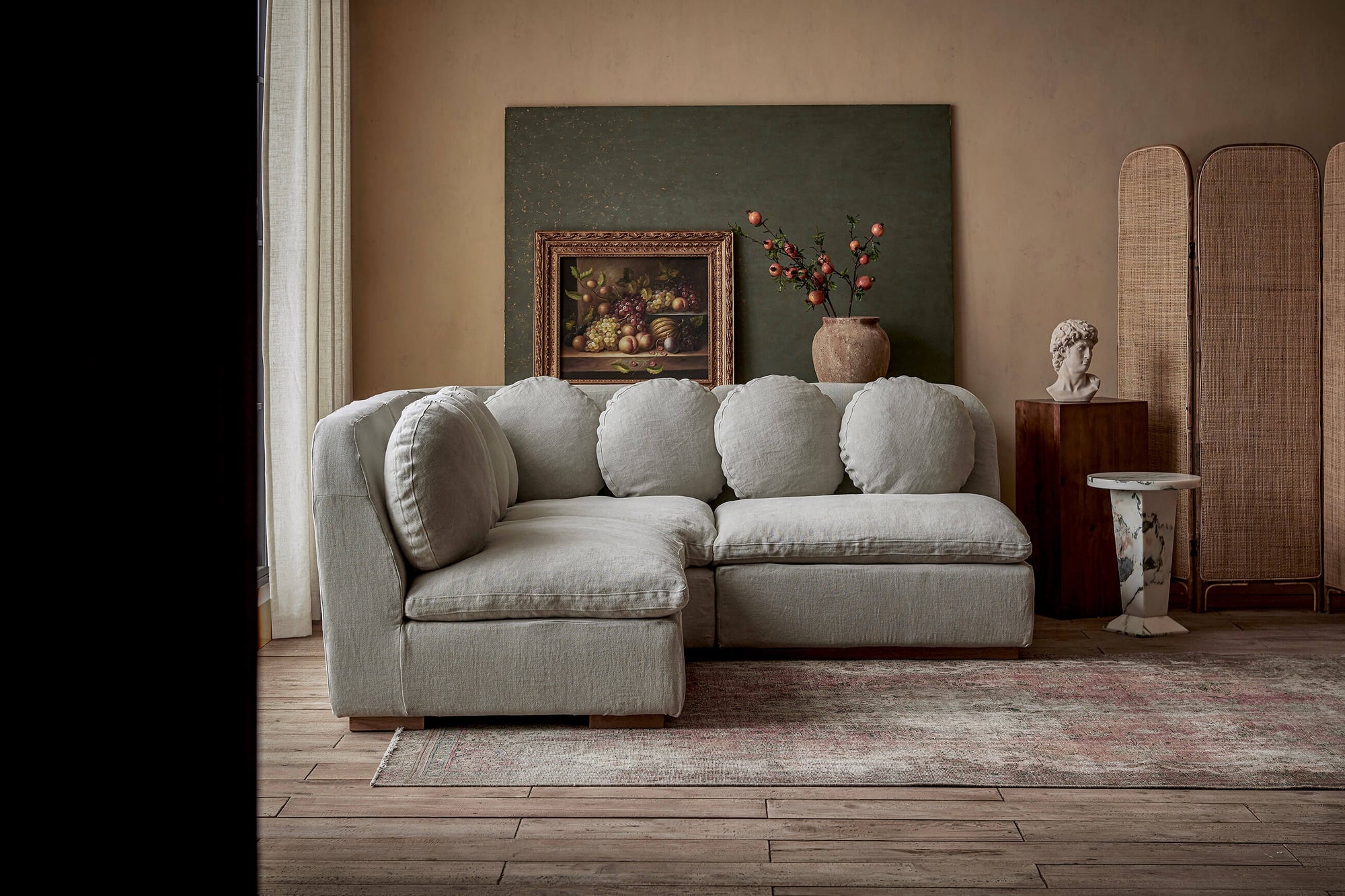 Olea Short Corner Sectional Sofa in Jasmine Rice, a light warm greige Medium Weight Linen placed in a room with home decor