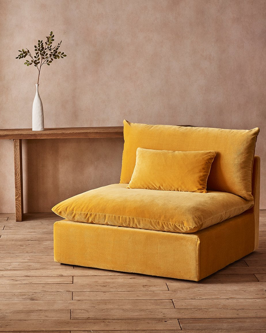 Aria Chair in Amber Coast, a golden yellow Washed Cotton Velvet, placed in a room in front of a console table