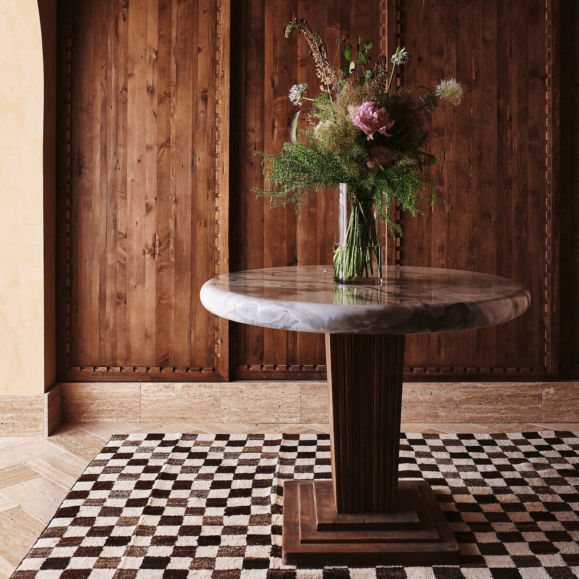 flowers in a vase on top of a custom Cordelia table