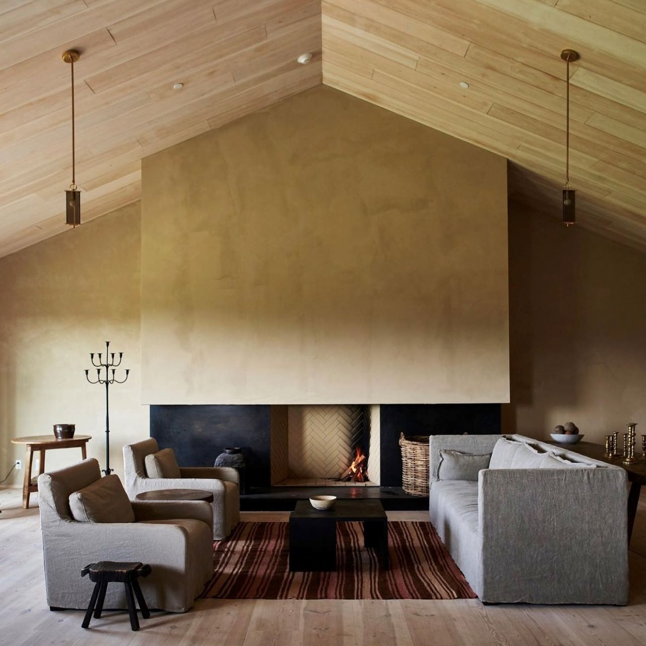 Monk Sofa and 2 Cadence Chairs placed on top of a rug in a decorated living room with a fireplace