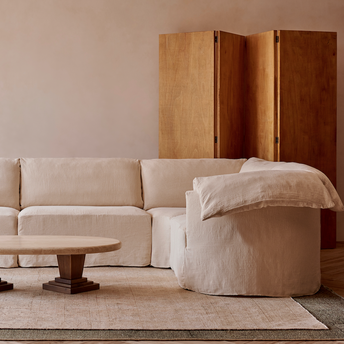 Loula Corner Sectional in Corn Silk, a light beige Washed Cotton Linen, placed in a decorated room around the Cordelia Coffee Table