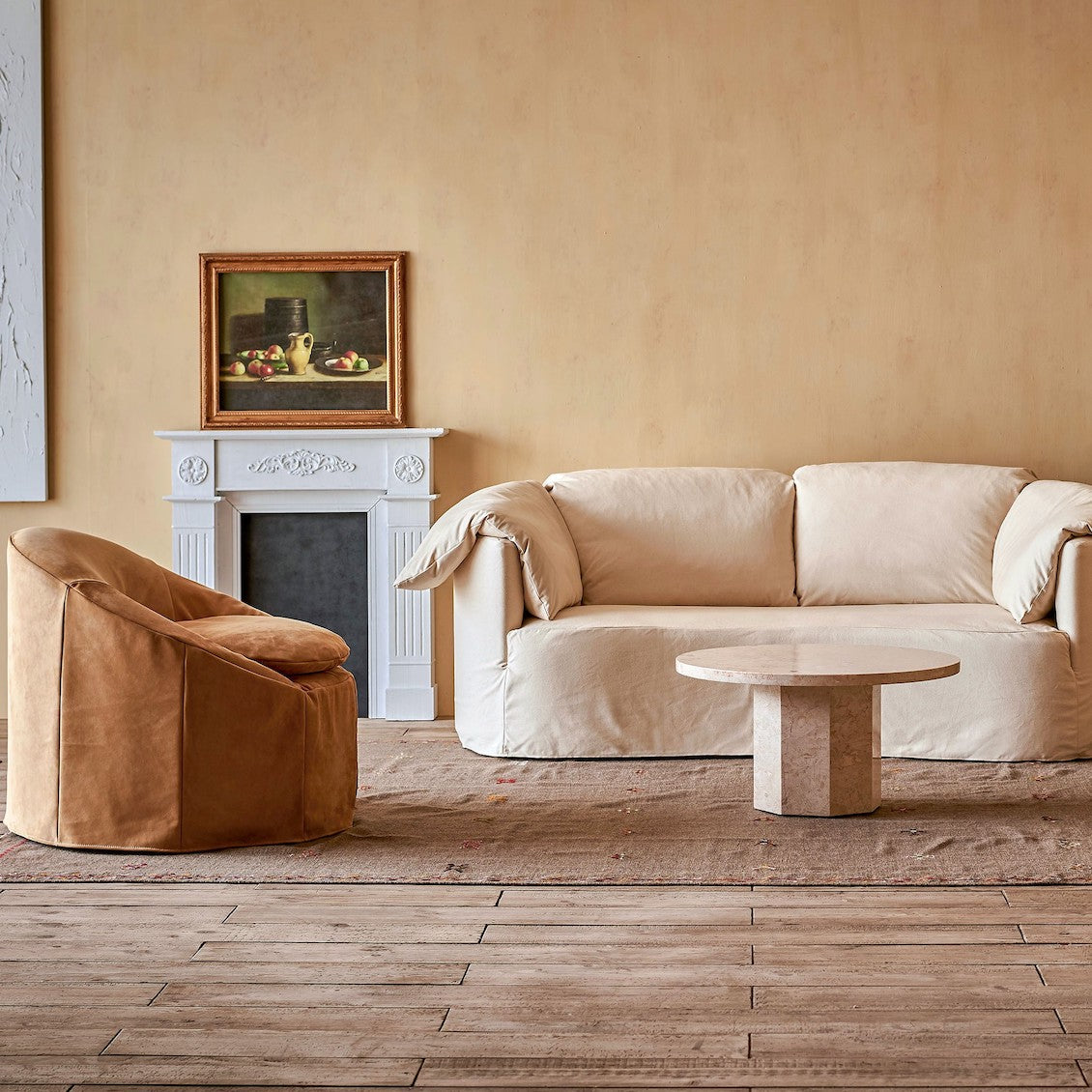 Loula Sofa in Beach Walk, a warm, creamy beige Cotton Canvas, placed in a room alongside the Ozzi Chair in Mojave Glow, a tan Meridian Leather