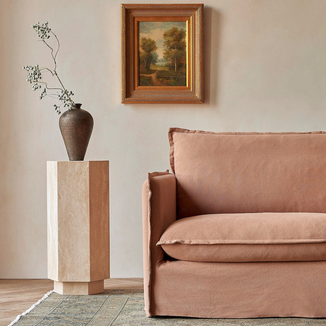 Neva Chair in Nectarine Dream, Thread-Dyed Cotton Linen, placed in a sunlit room beside a decorative pillar and vase