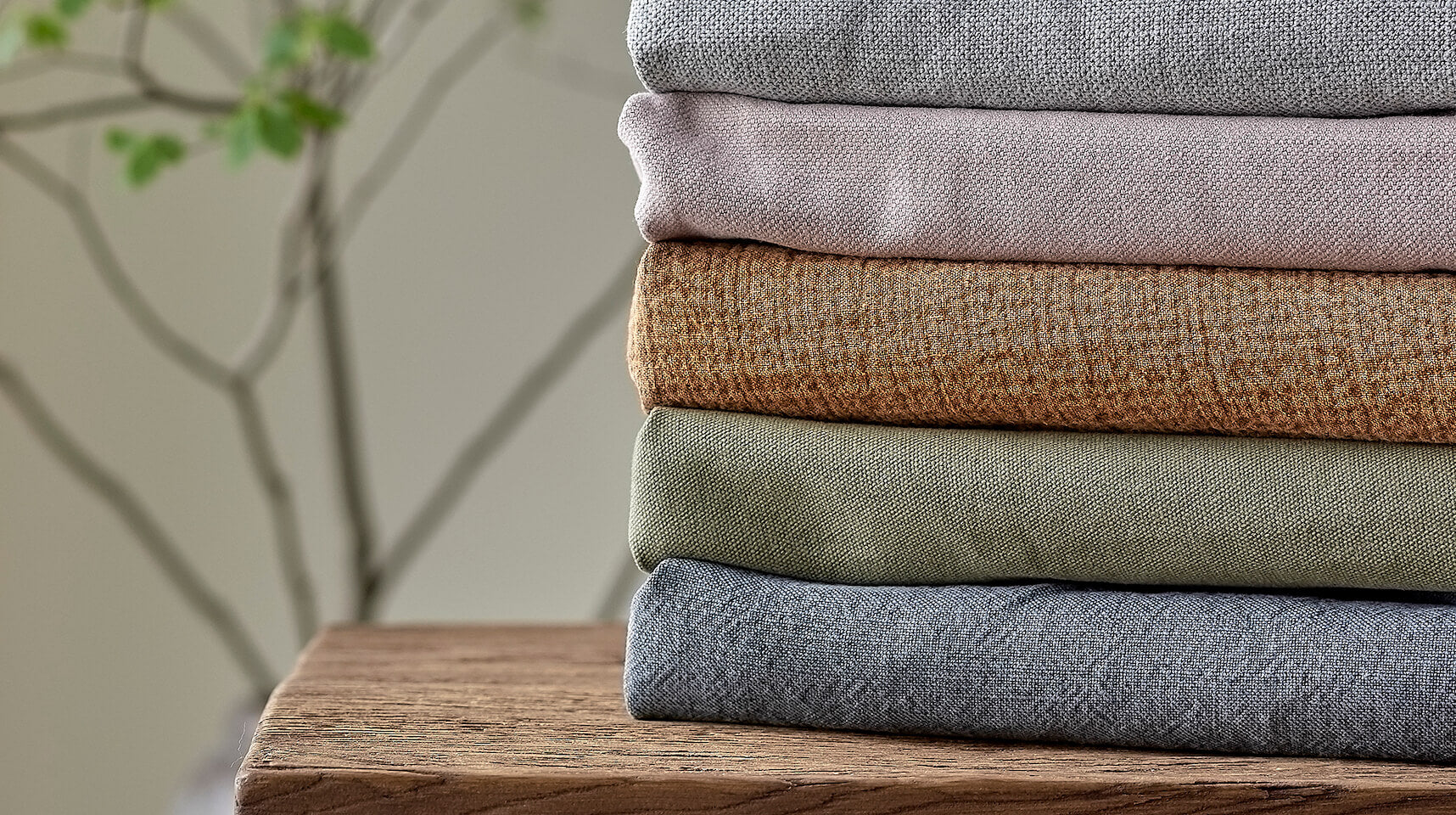 Stack of various Cotton and Linen Fabrics placed on top of a table