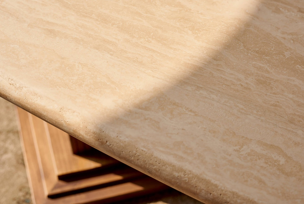 Close up of the Cordelia Dining Table in Turkish Galata Travertine in a warm beige with gold and pink undertones. Various veining, color variations, and pitting throughout. 