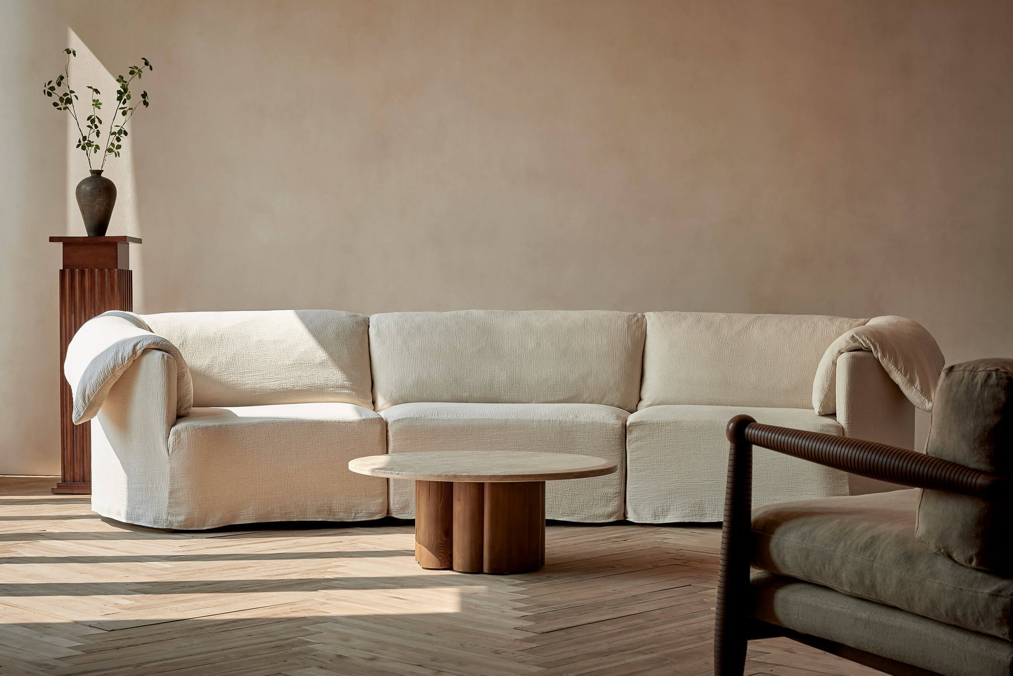 Loula Sectional Sofa in Corn Silk, a light beige Washed Cotton Linen, placed in a sunlit room with the Enzo Coffee Table