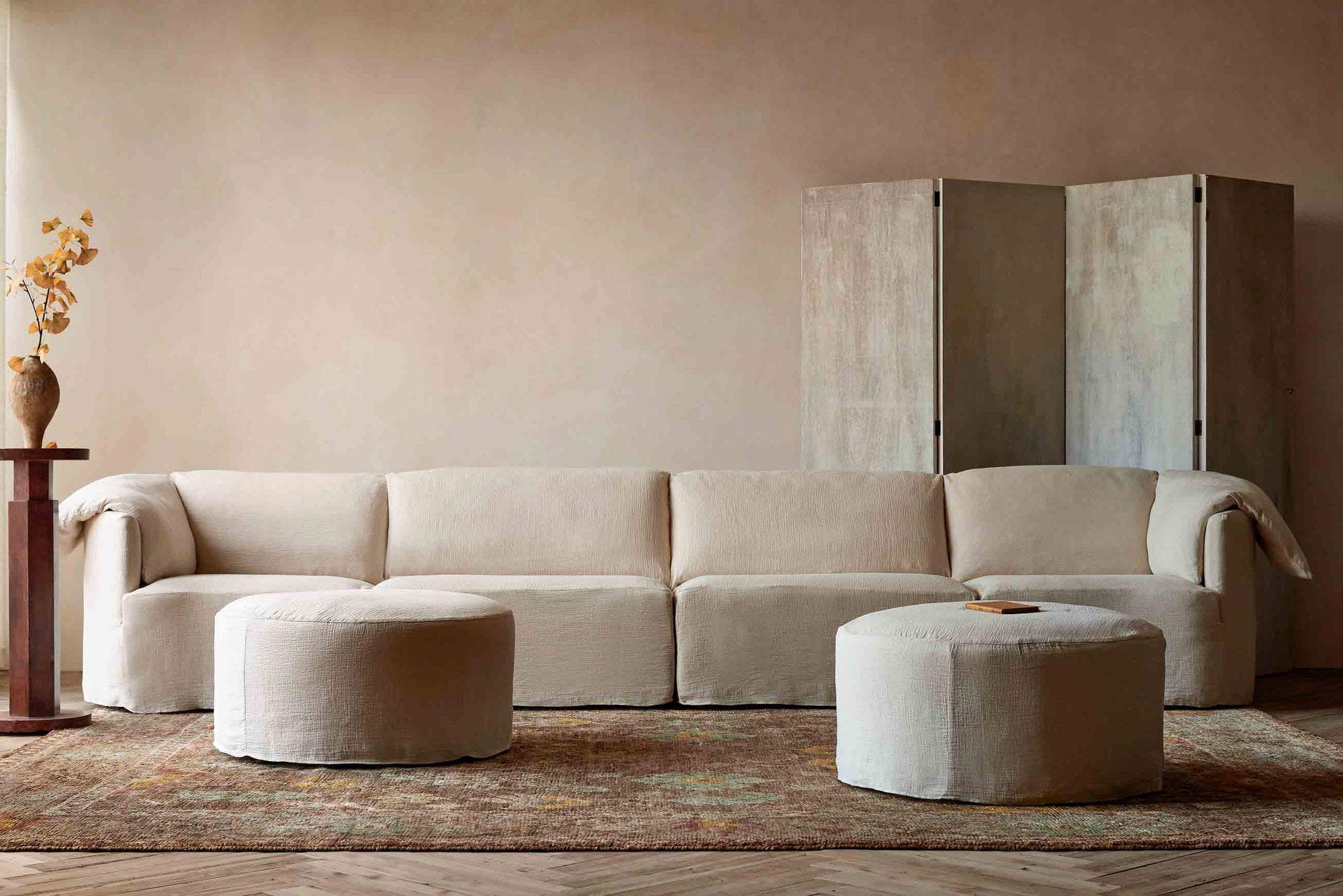 Loula U-Shape Sectional in Corn Silk, a light beige Washed Cotton Linen, placed in a room on top of a patterned rug