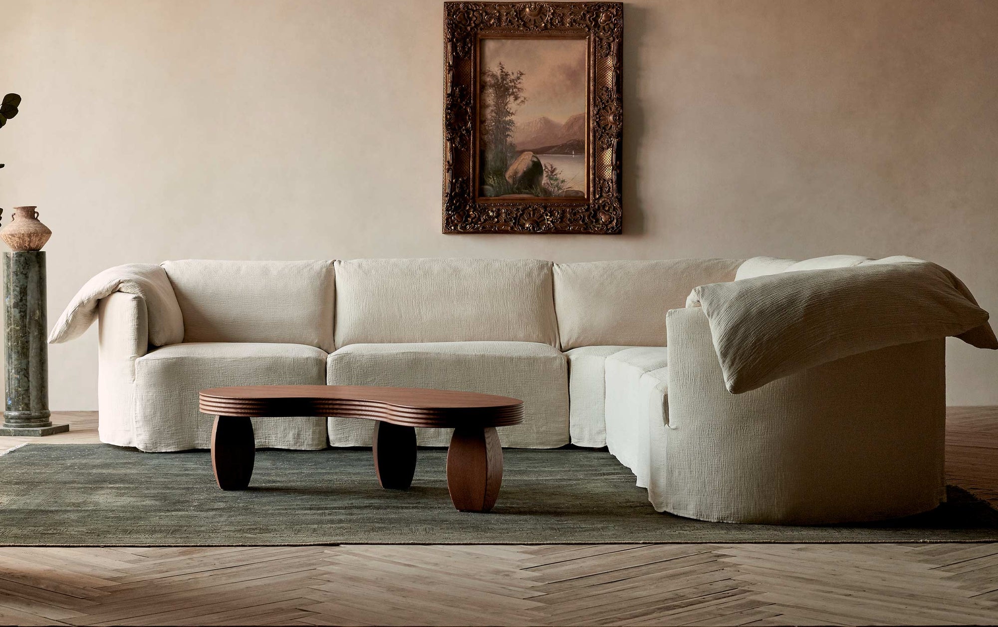 Loula Corner Sectional in Corn Silk, a light beige Washed Cotton Linen, placed in a decorated room around the Pisces Coffee Table