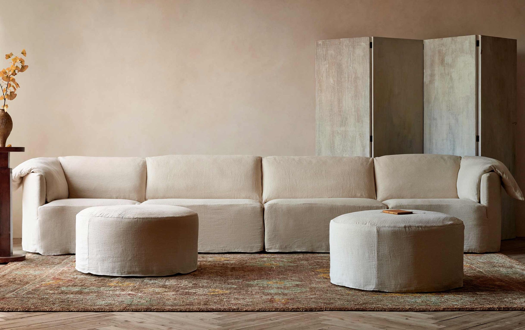 Loula U-Shape Sectional in Corn Silk, a light beige Washed Cotton Linen, placed on top of a patterned rug