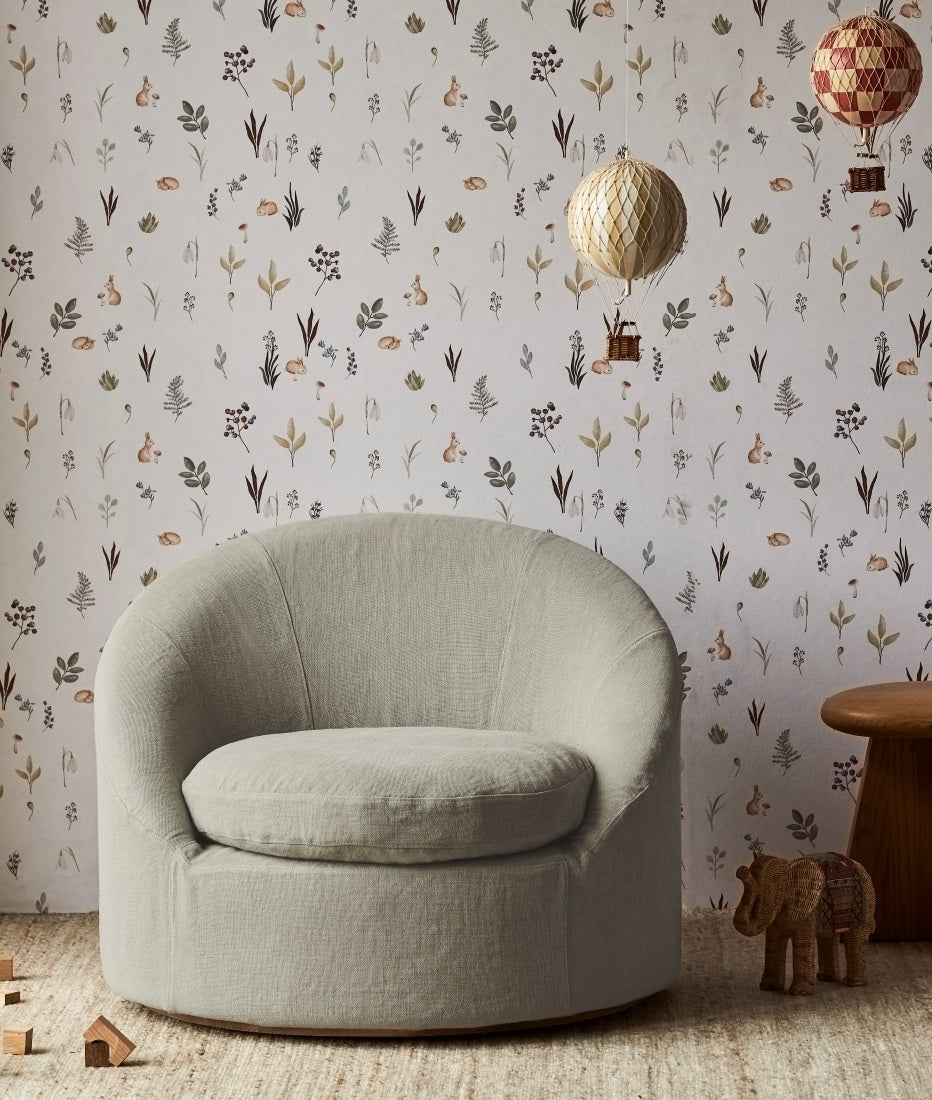 Olea Swivel Chair in Jasmine Rice placed in a child's playroom alongside toys and decorations