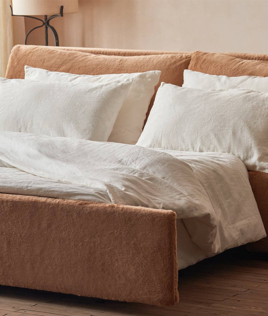 An opened Aria Sleeper Sofa in Recycled Faux Fur Kiwi Fuzz with white pillows and bedding.