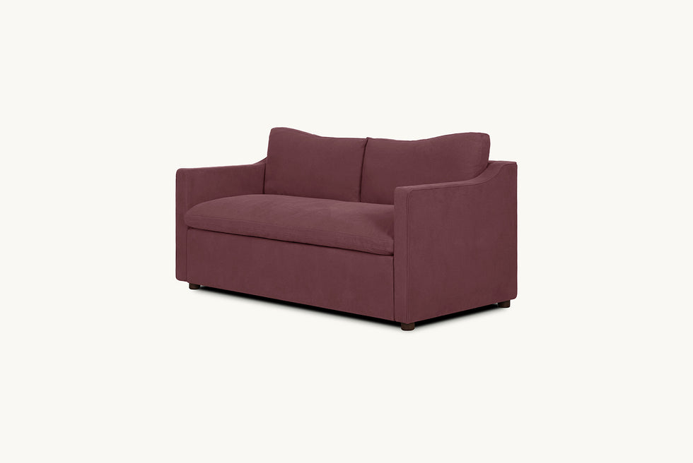 Angled view of Amelia Sleeper Sofa in Summer Plum, a soft maroon Thread-Dyed Cotton Linen