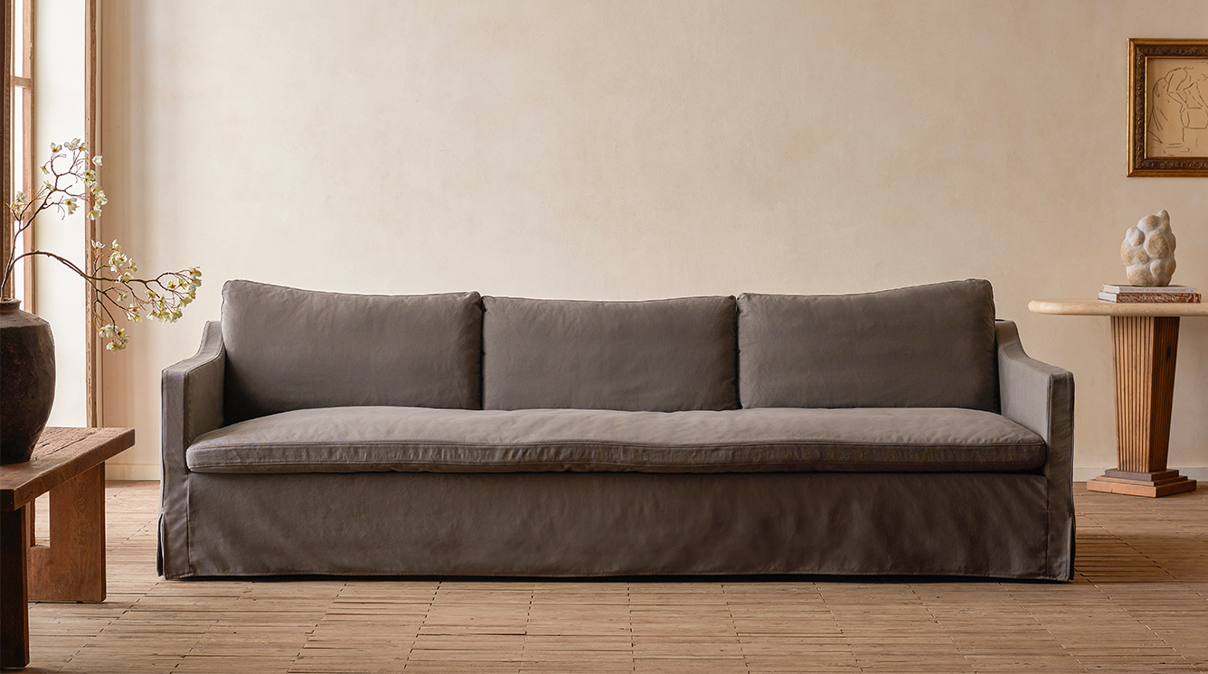 Sixpenny Amelia sofa, cotton canvas moon dust in a room with wooden flooring and a neutral wall.