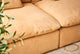 Slide #6 Close up of Aria Leather Sectional Sofa in Mojave Glow, a tan Meridian Leather, with a tall plant peeking into the frame