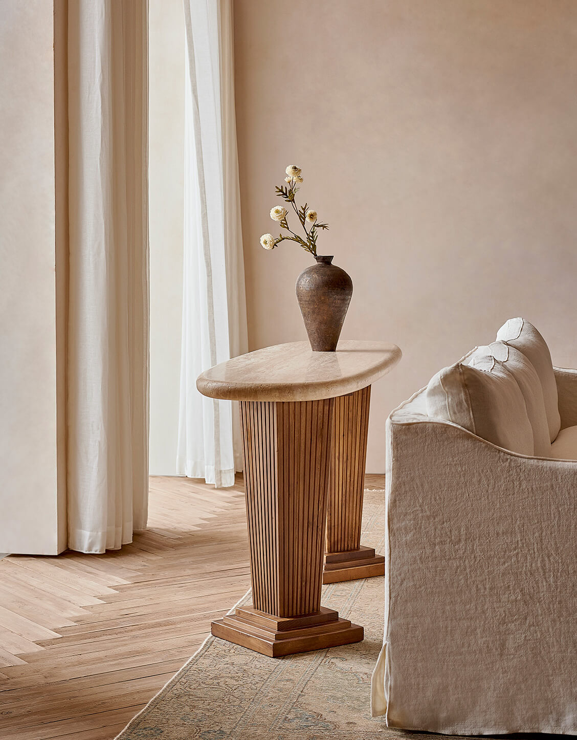 Cordelia Console Table in Galata Travertine and Heritage Pine placed behind the Amelia Sofa