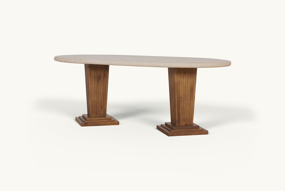 Angled view of the Cordelia Dining Table in Turkish Galata Travertine in a warm beige with gold and pink undertones. Various veining, color variations, and pitting throughout. Legs made of 100% Reclaimed Chinese Pine