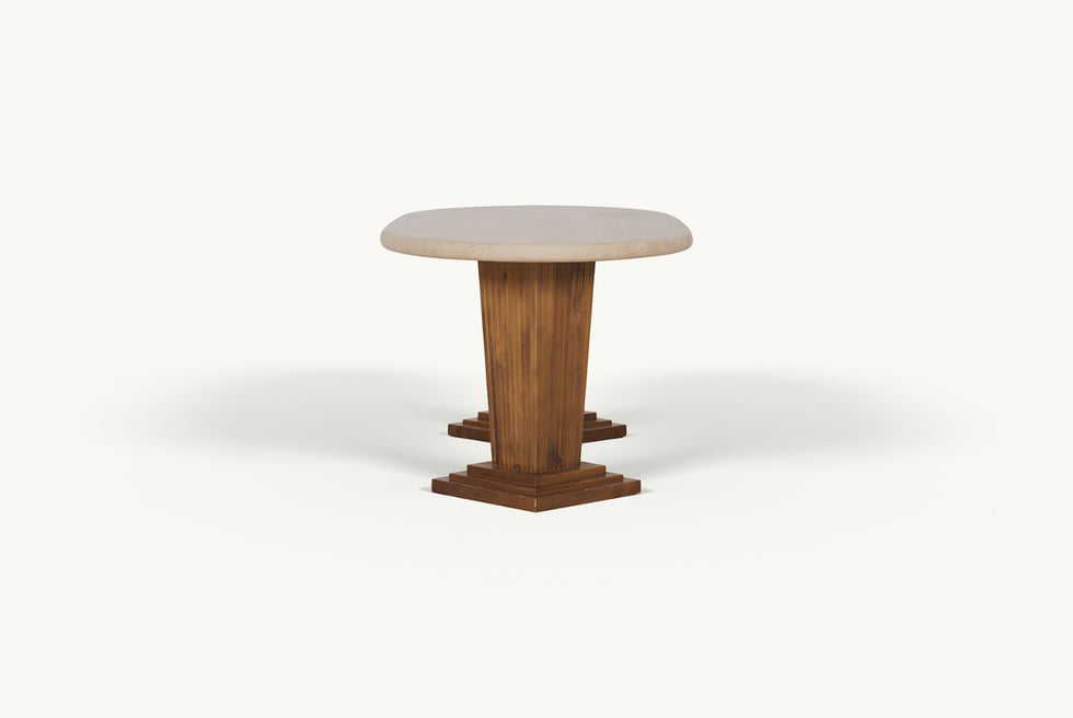 Side view of the Cordelia Dining Table in Turkish Galata Travertine in a warm beige with gold and pink undertones. Various veining, color variations, and pitting throughout. Legs made of 100% Reclaimed Chinese Pine