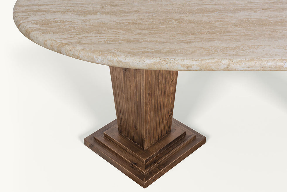 Detail view of the Cordelia Dining Table in Turkish Galata Travertine in a warm beige with gold and pink undertones. Various veining, color variations, and pitting throughout. Legs made of 100% Reclaimed Chinese Pine