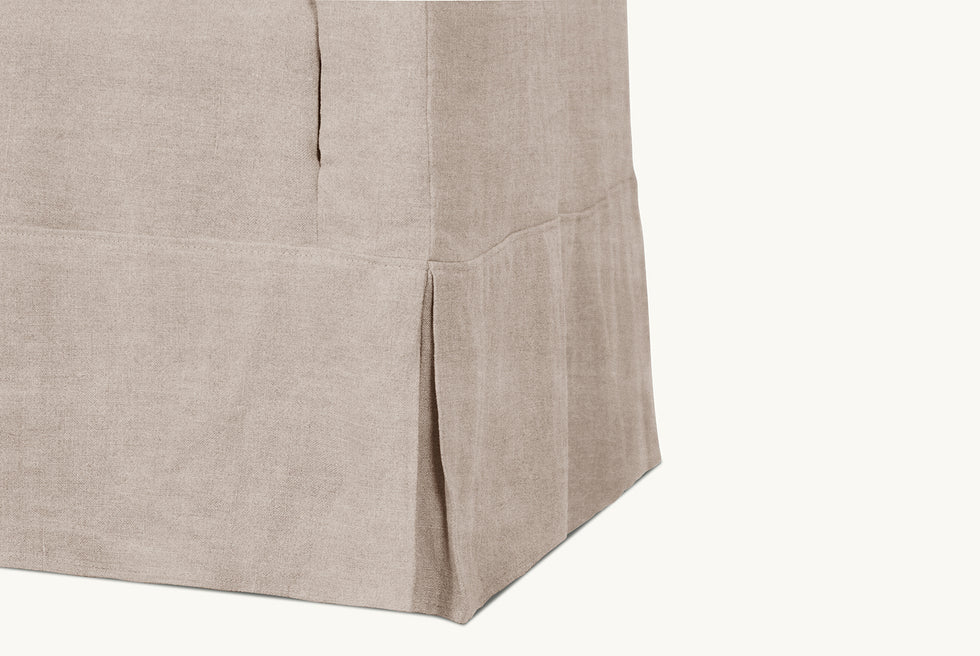 Detail view of the pleated skirt on the Dalia Chair in Oat Flour, a medium taupe Light Weight Linen