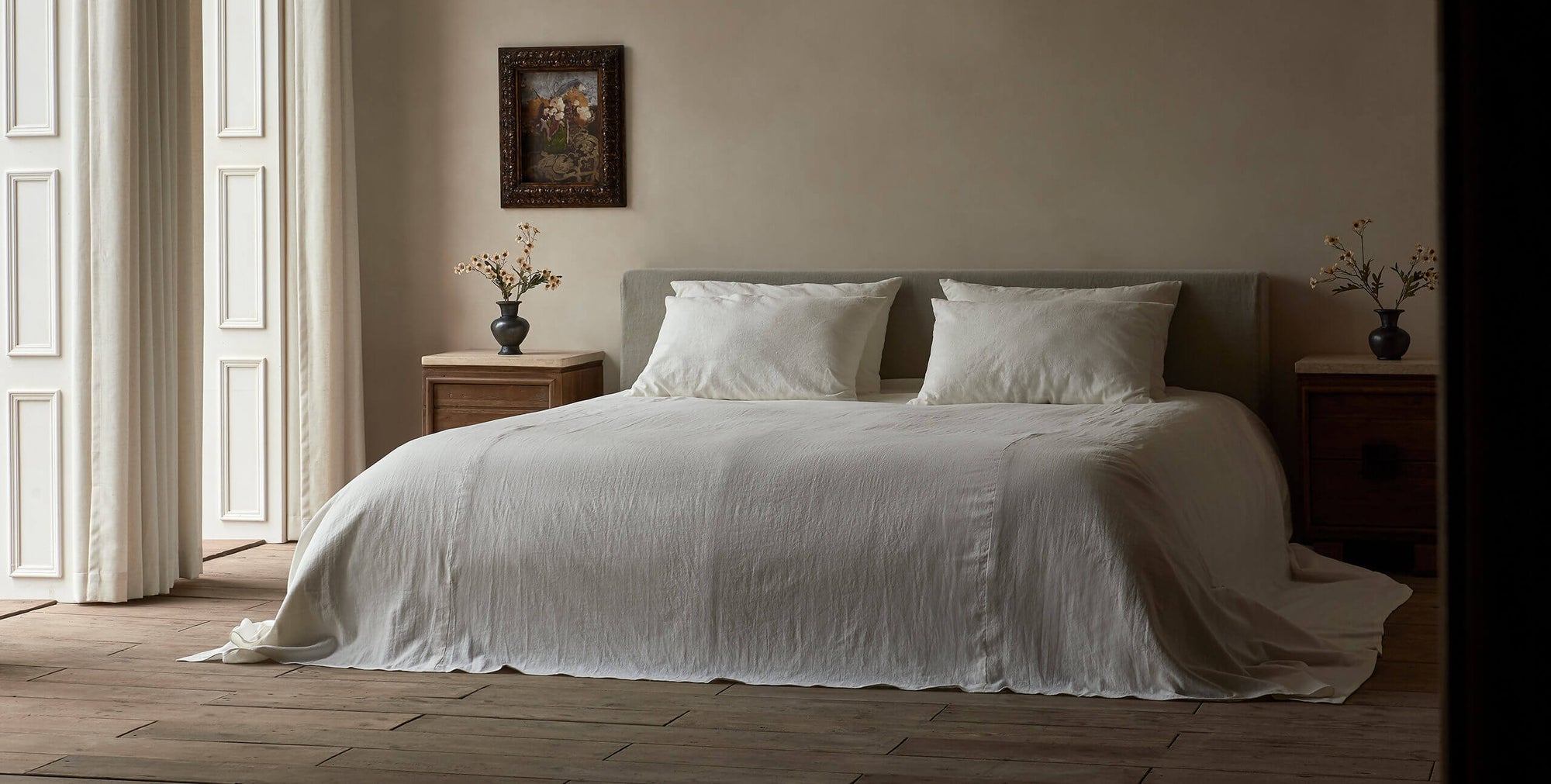 Devyn King Sized Bed Frame in Jasmine Rice, a light warm greige Medium Weight Linen, made up with white linen bedding
