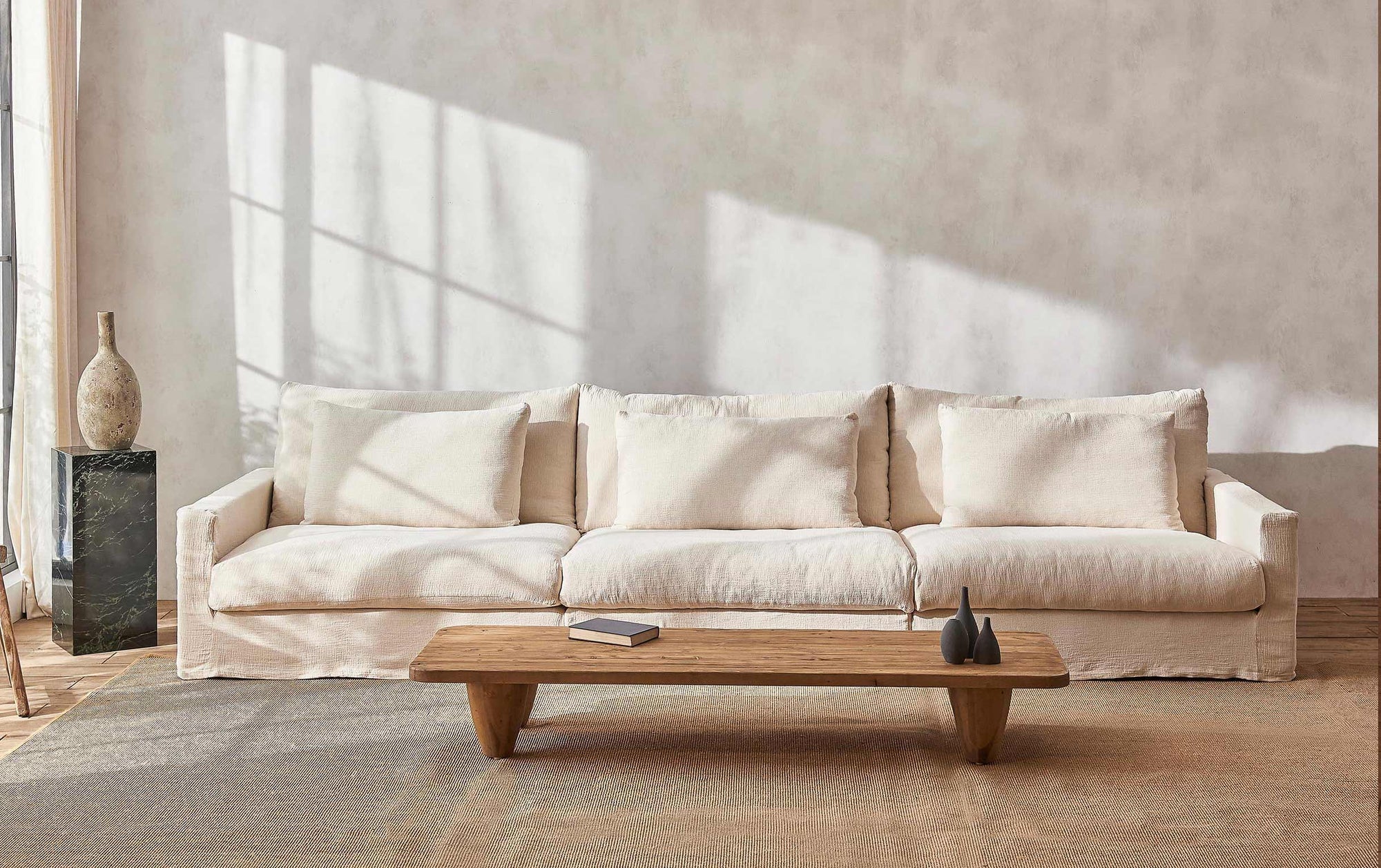 Devyn Sectional Sofa in Corn Silk, a light beige Washed Cotton Linen, placed behind a Theo Coffee Table