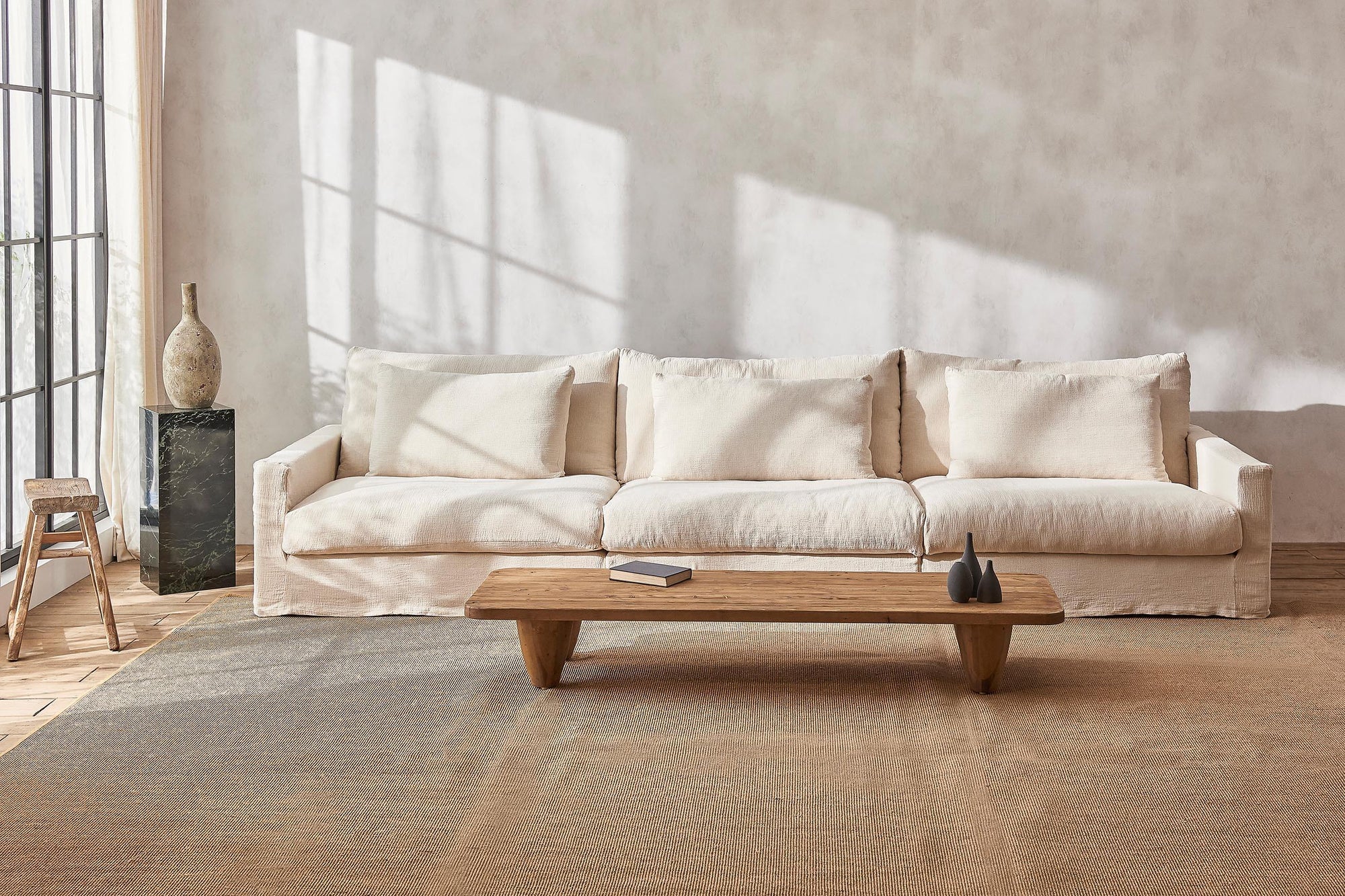 Devyn Sectional Sofa in Corn Silk, a light beige Washed Cotton Linen, placed in a decorated sunlit room with a Theo Coffee Table