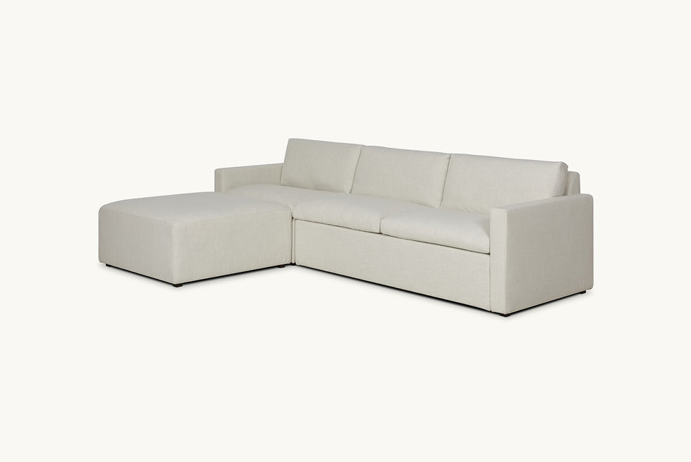 Angled view of Devyn Sleeper Chaise Sectional in Young Coconut, a powdery white Recycled Poly Linen