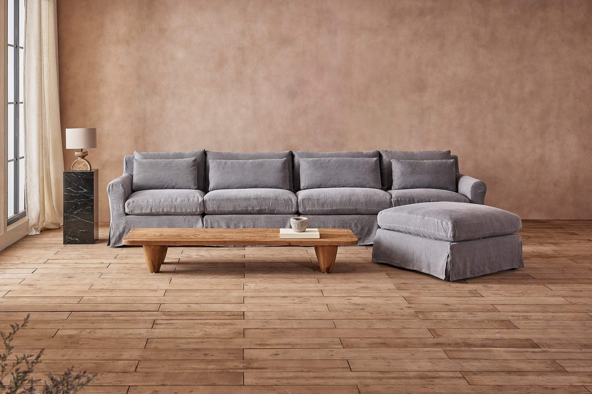 Elias 5-piece Chaise Sectional Sofa in Ink Cap, a medium cool grey Light Weight Linen, placed in a room with the Theo Coffee Table
