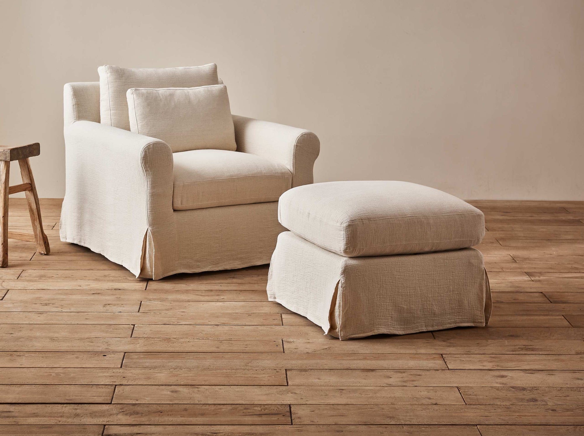 Elias Chair Ottoman in Corn Silk, a light beige Washed Cotton Linen, placed in a room with a matching Elias Chair