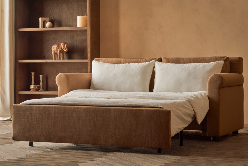Elias Sleeper Sofa in Branch Out, a golden brown linen-like recycled polyester, pulled out and made up with white linen bedding