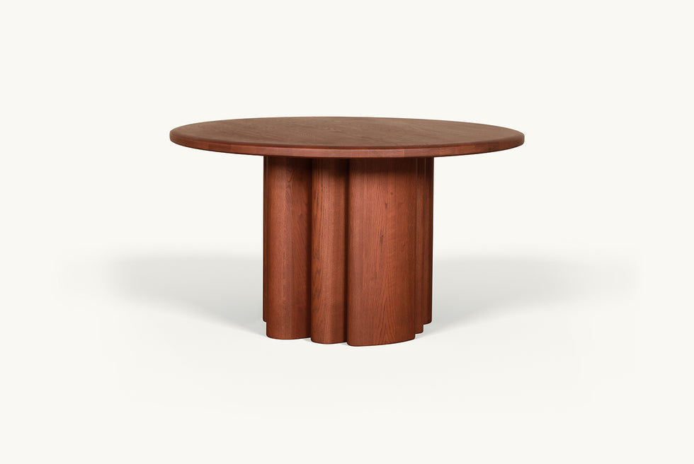 Angled view of Enzo Round Dining Table in Spiced Oak, a smokey paprika-hued 100% American red oak