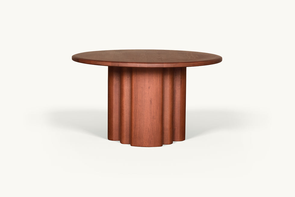 Side view of Enzo Round Dining Table in Spiced Oak, a smokey paprika-hued 100% American red oak