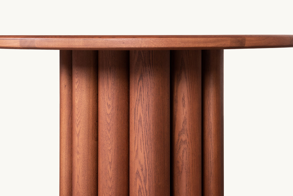Close view of Enzo Round Dining Table in Spiced Oak, a smokey paprika-hued 100% American red oak