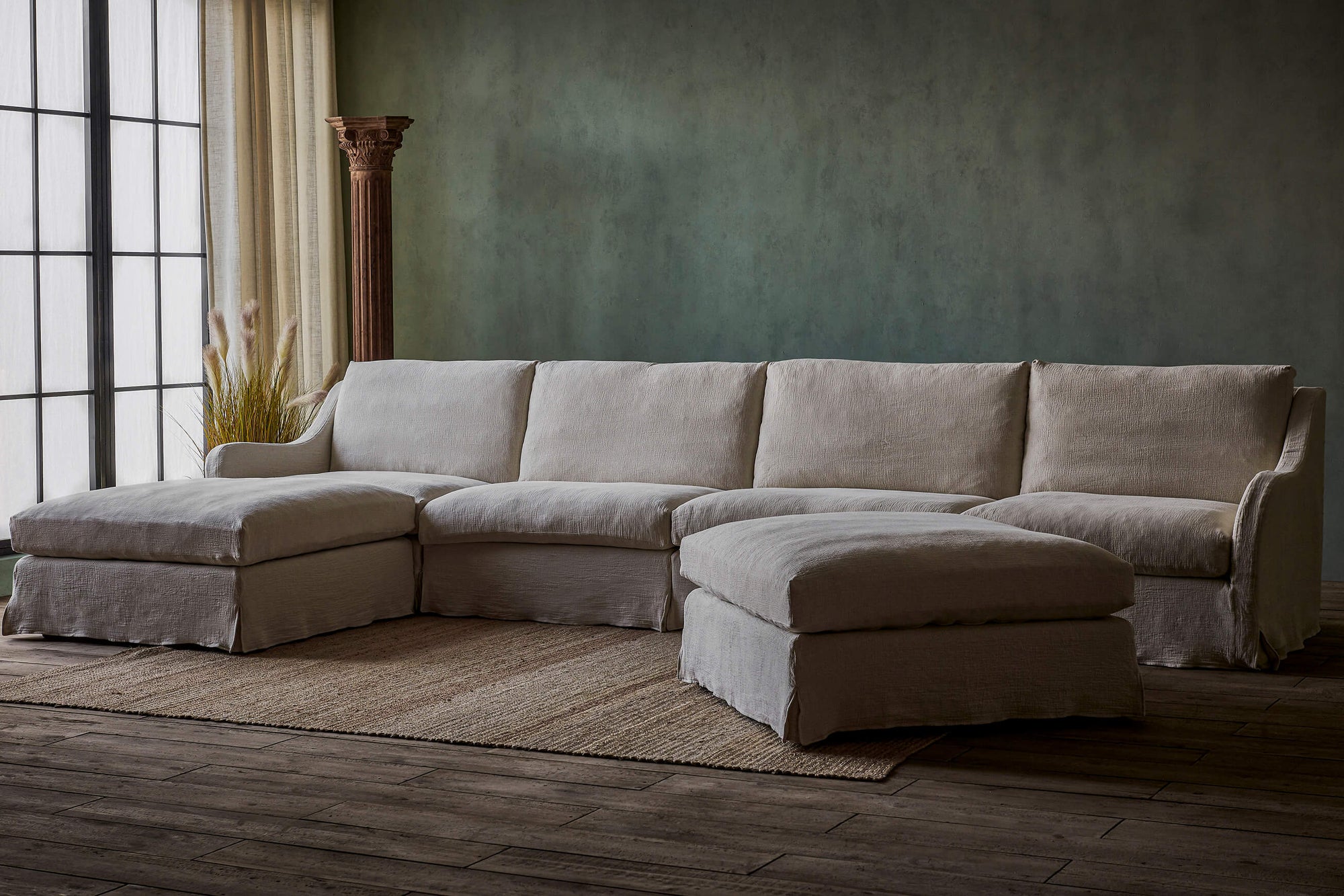 Esmé Sectional Ottoman in Corn Silk, a light beige Washed Cotton Linen, styled in a room with the Esmé Sectional Sofa placed next to a window