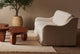 Slide #6 Esmé 84" Sofa in Corn Silk, a light beige Washed Cotton Linen, placed on a beige rug in a room with two Pisces Coffee Tables and a potted tree
