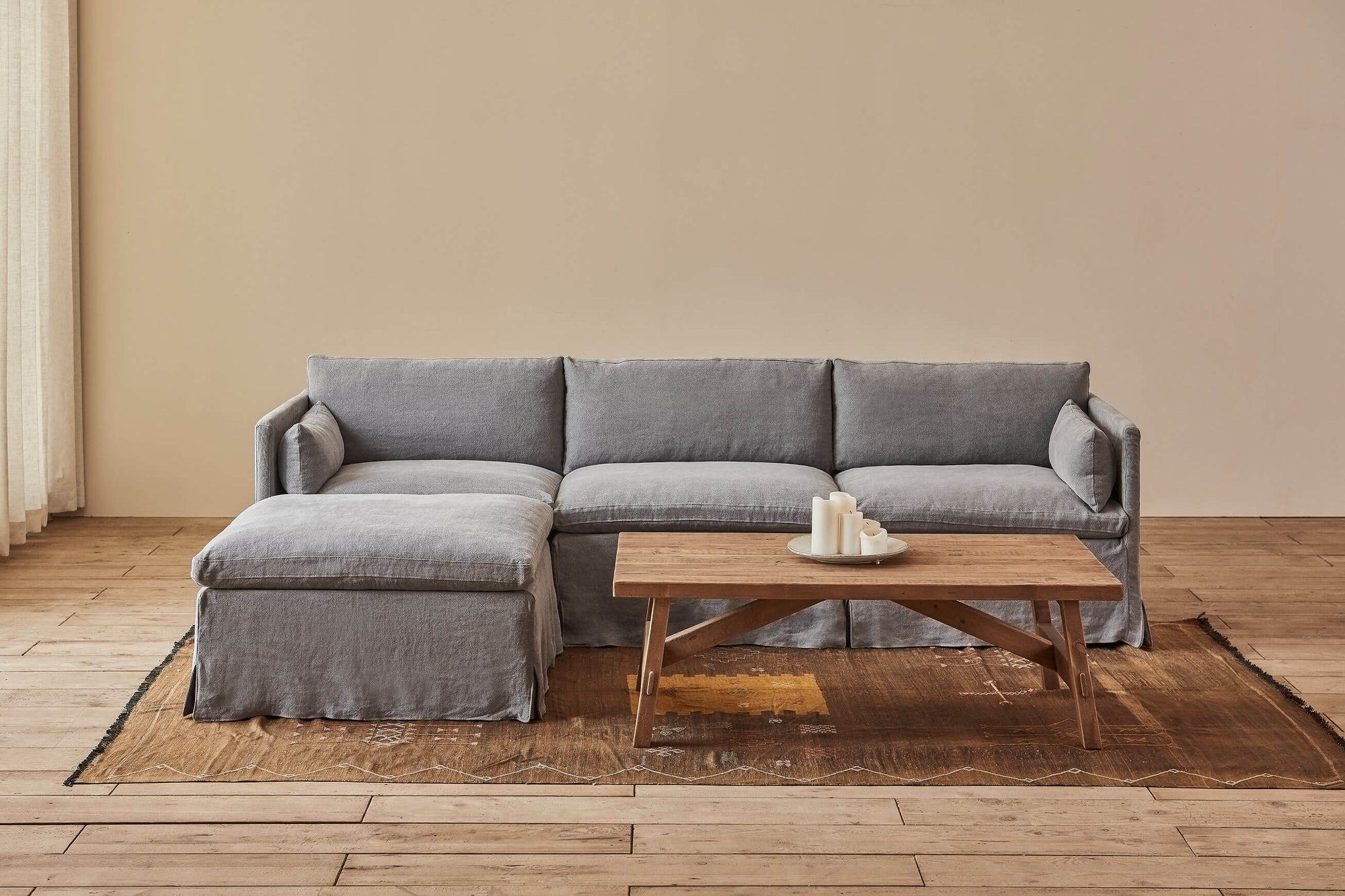 Gabriel 4-piece Chaise Sectional Sofa in Ink Cap, a medium cool grey Light Weight Linen, placed in a bright room beside a coffee table