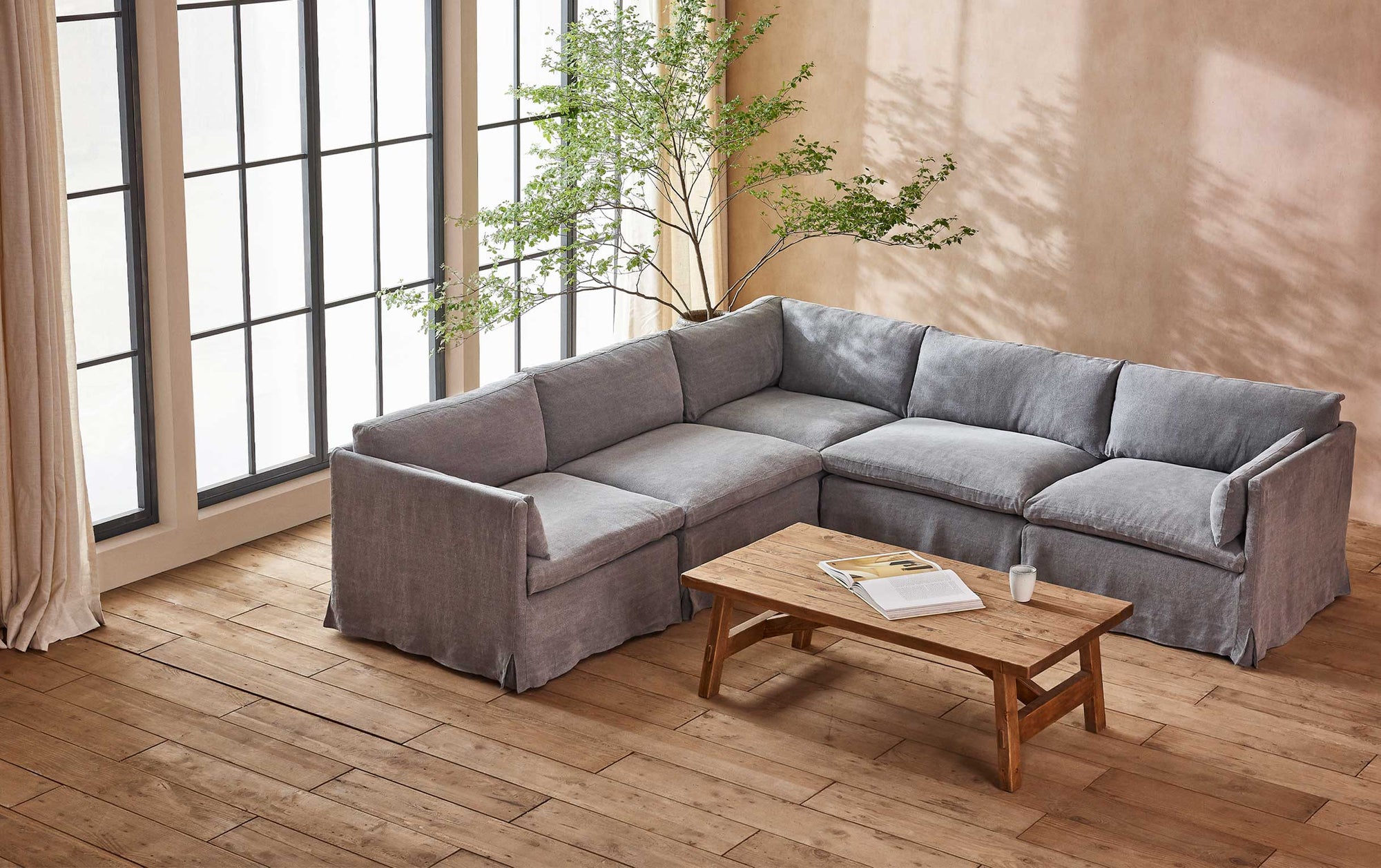 Gabriel Corner Shape Sectional Sofa in Ink Cap, a medium cool grey Light Weight Linen, placed around a coffee table