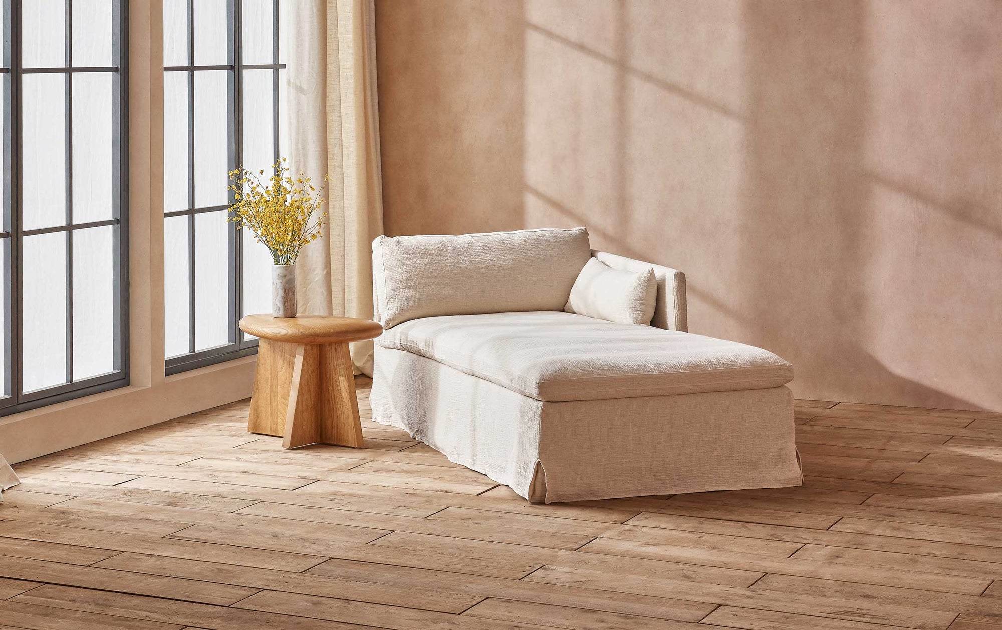 Gabriel Right Arm Facing Daybed in Corn Silk, a light beige Washed Cotton Linen, placed in a room next to a window and coffee table