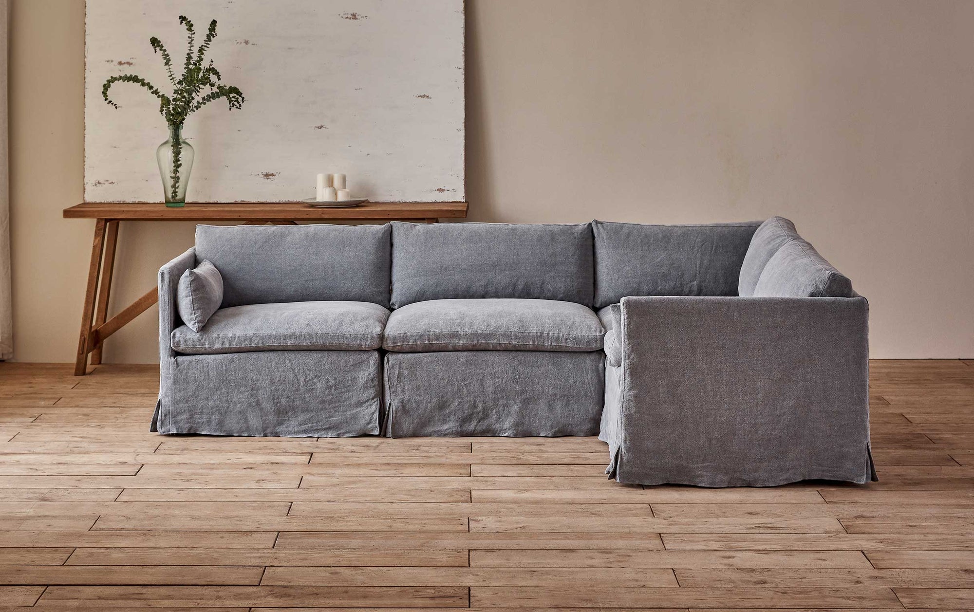 Gabriel L-Shape Sectional Sofa in Ink Cap, a medium cool grey Light Weight Linen placed ion front of a console table