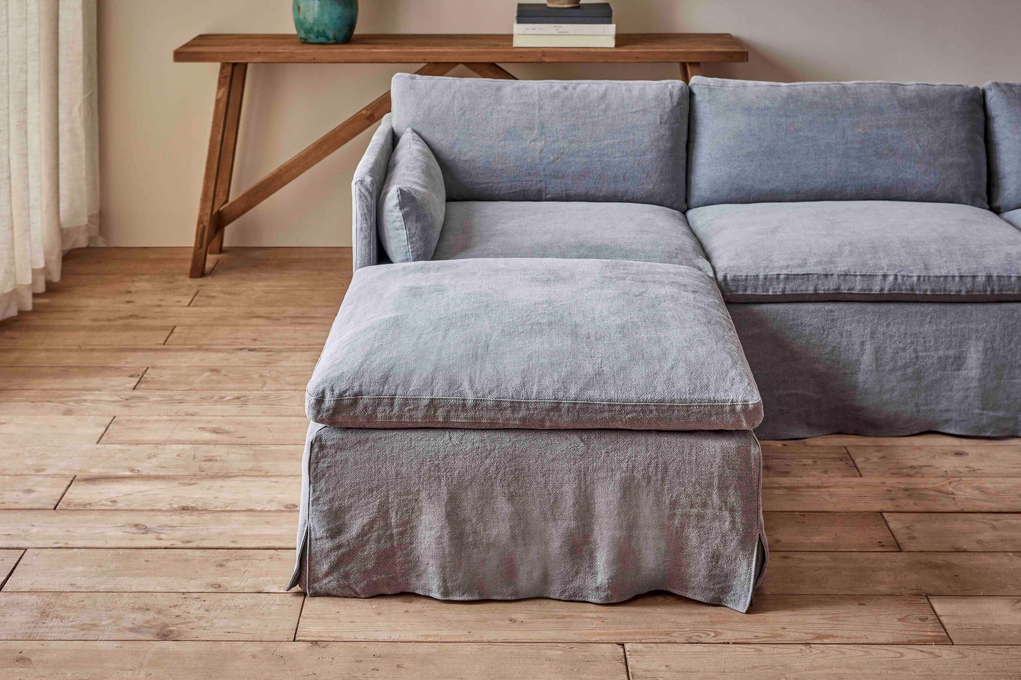 Gabriel Sectional Ottoman in Ink Cap, a medium cool grey Light Weight Linen, placed in a room with the Gabriel Sectional Sofa