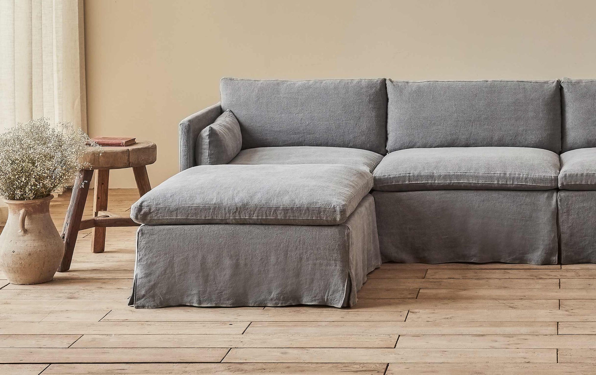 Gabriel Sectional Ottoman in Ink Cap, a medium cool grey Light Weight Linen, placed in a room with the Gabriel Sectional Sofa