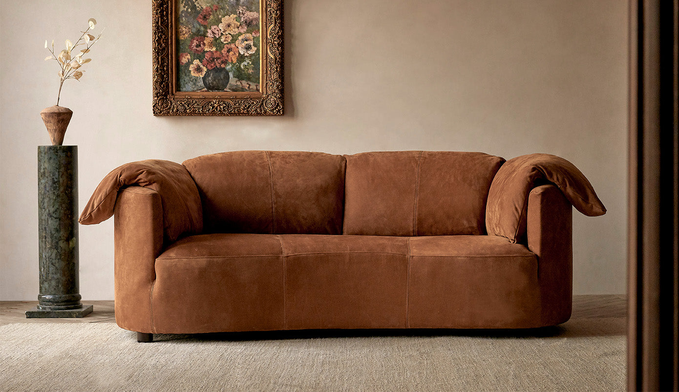 loula leather sofa meridian leather sunset canyon in a room with a decorative painting and plant.